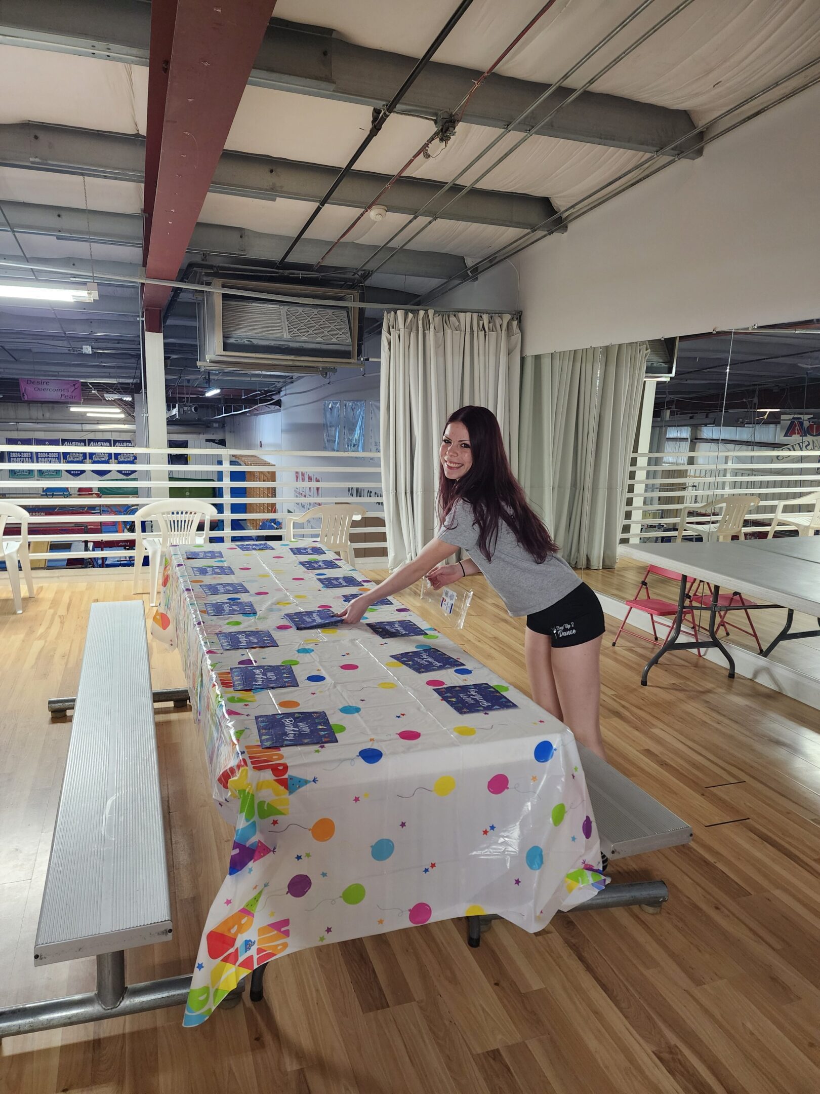 A woman preparing a colorful table for an event indoors.